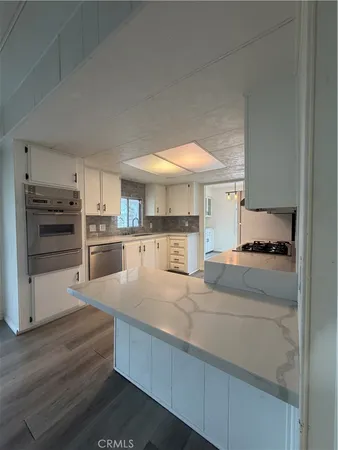 a large kitchen with kitchen island a sink stainless steel appliances and cabinets