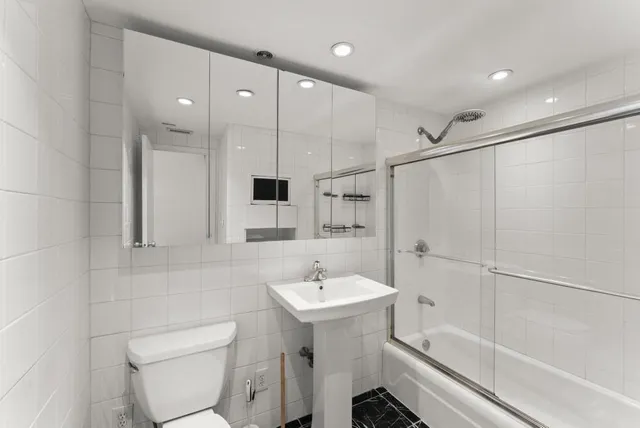 a bathroom with a sink a toilet and shower