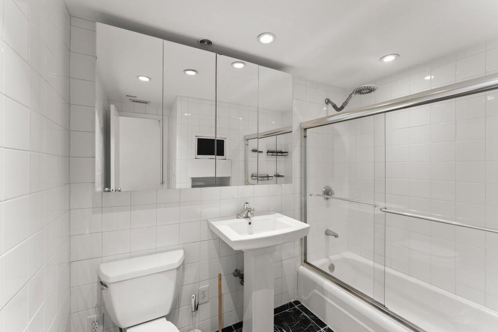 2285 Peachtree Street Northeast, Unit 801 Atlanta, GA 30309 - Photo 15 of 30 a bathroom with a sink a toilet and shower