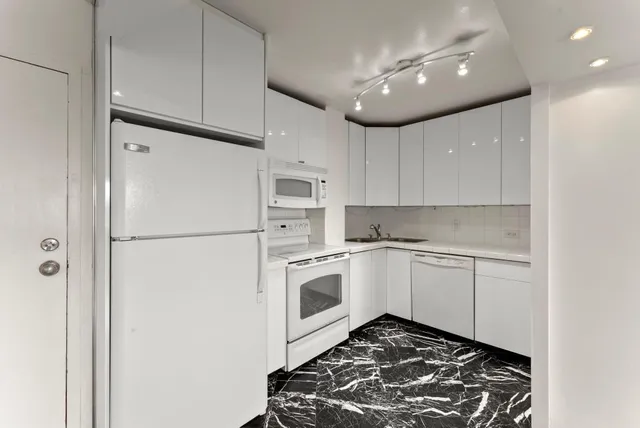 a kitchen with white cabinets and white appliances