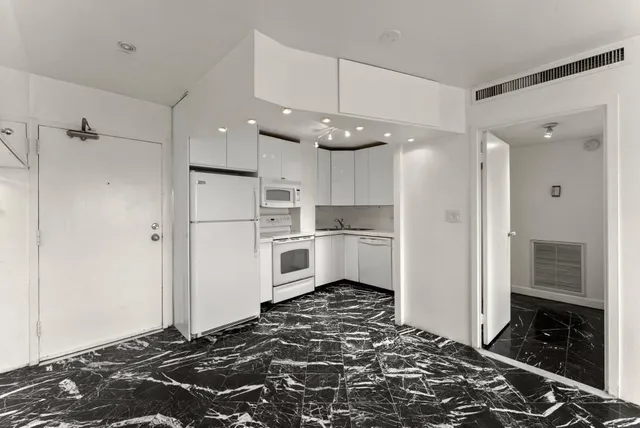 a kitchen with stainless steel appliances granite countertop a refrigerator and a stove top oven