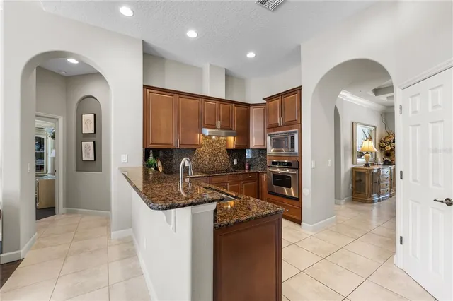 a kitchen with granite countertop a refrigerator and a sink