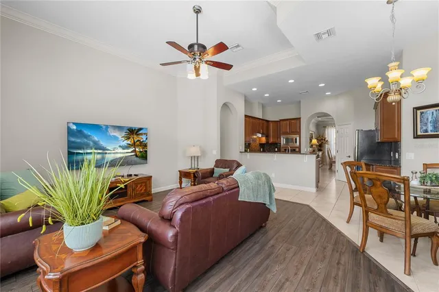 a living room with furniture a potted plant and a chandelier