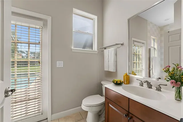 an aerial view of a tennis ground and a cars park side of the road