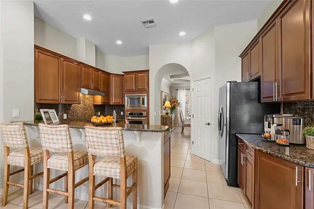 a kitchen with stainless steel appliances granite countertop a refrigerator and microwave