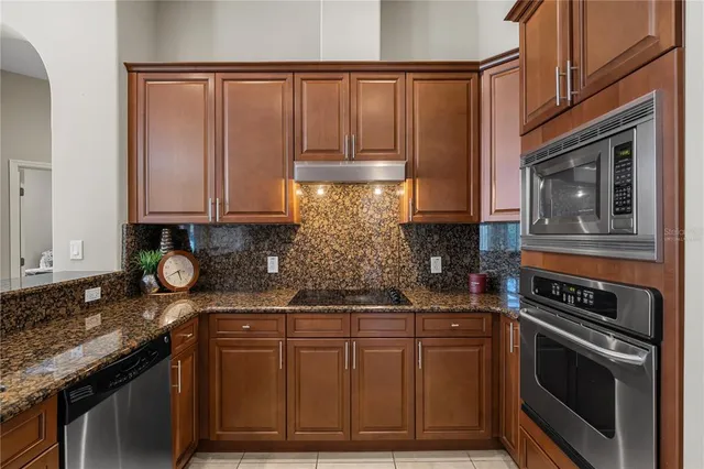 a kitchen with stainless steel appliances granite countertop a stove and cabinets