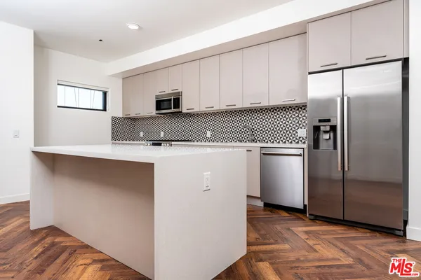 a kitchen with granite countertop white cabinets and stainless steel appliances