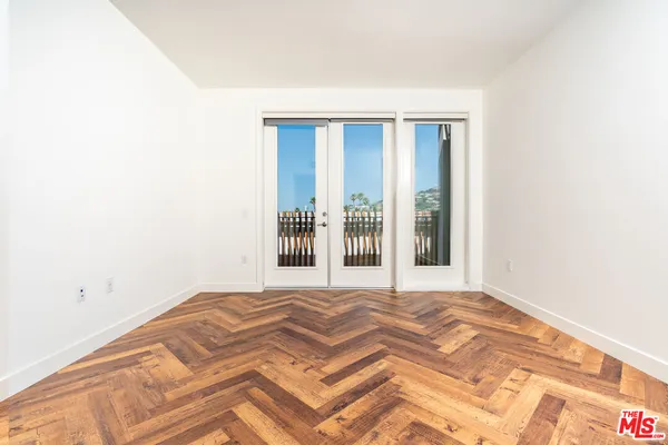 a view of a room with wooden floor and a window
