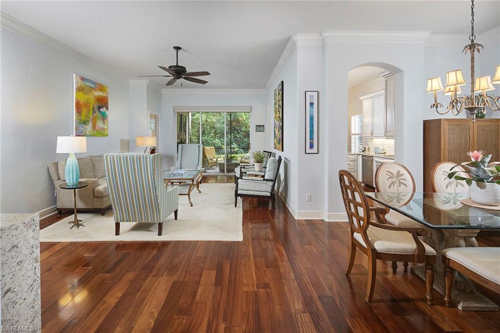 a view of a dining room with furniture a chandelier and wooden floor