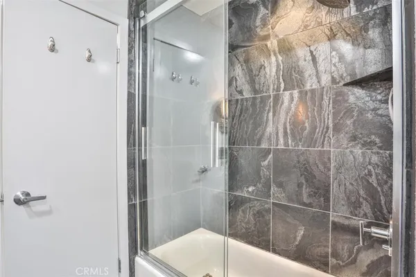 a bed sitting in a bedroom next to a window with a flat tv screen and a fireplace