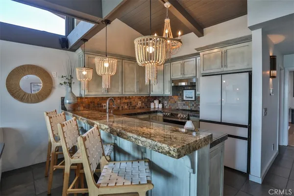 a kitchen with granite countertop a sink a stove and cabinets