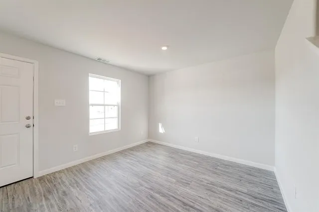 a view of an empty room with wooden floor