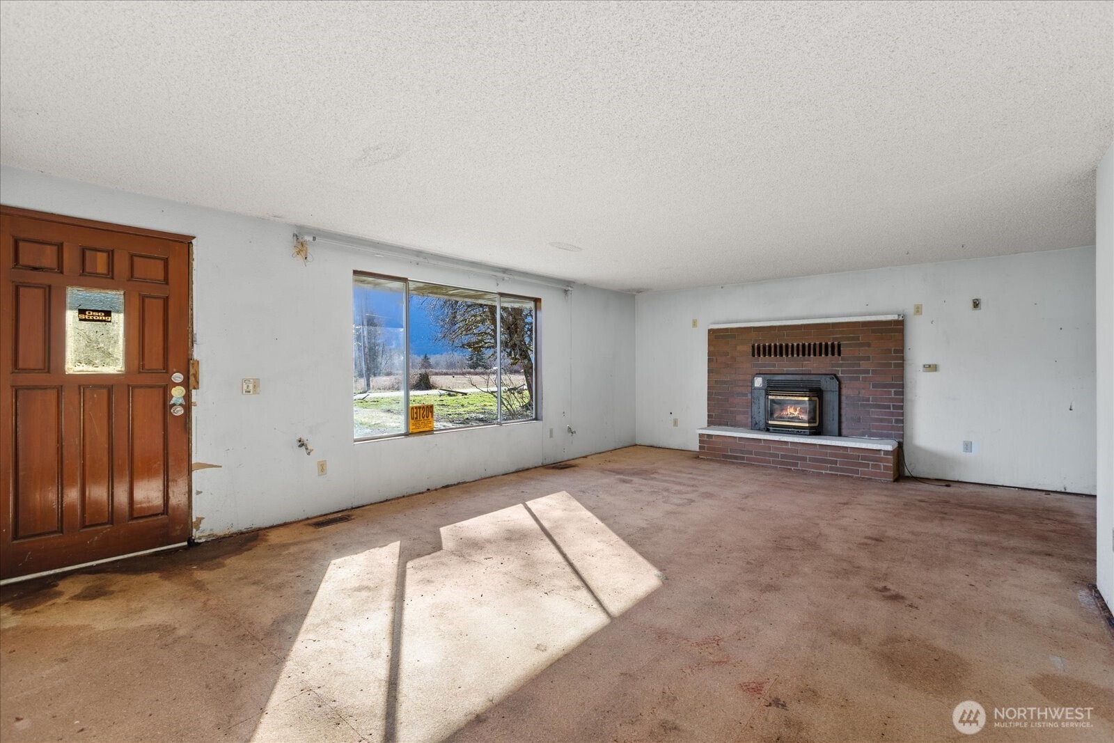38425 Swede Heaven Road Arlington, WA 98223 - Photo 4 of 36 an empty room with windows and fireplace