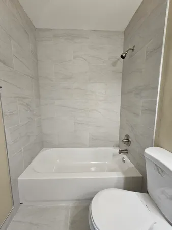 a bathroom with a toilet and a bath tub