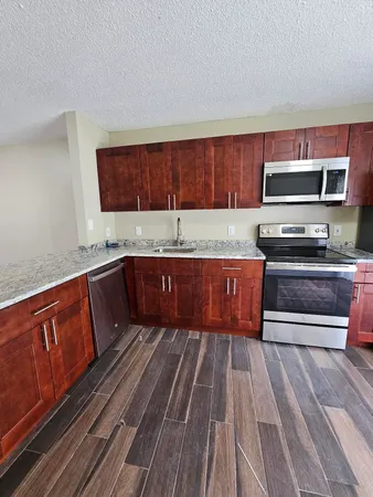 a kitchen with wooden floors and wooden cabinets