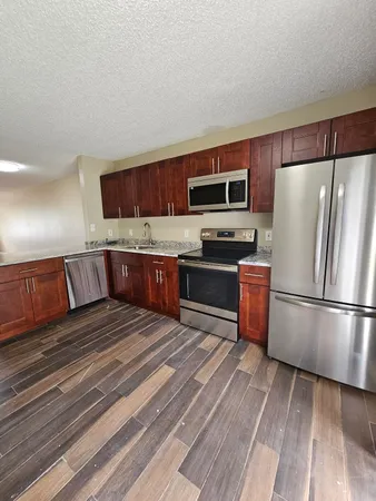 a kitchen with stainless steel appliances a refrigerator and a stove top oven
