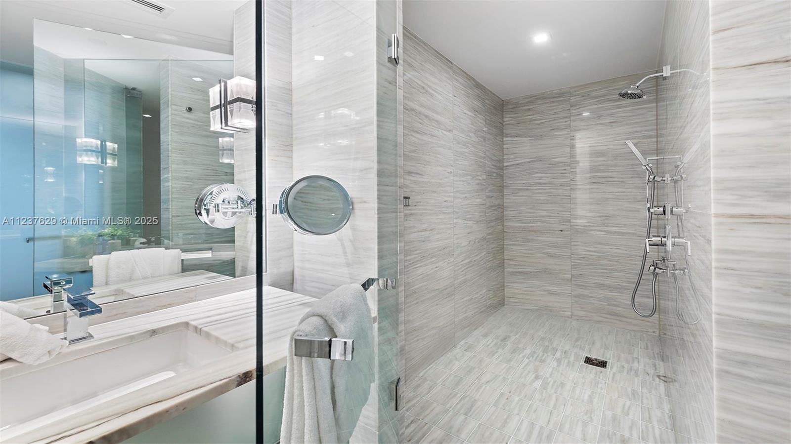 2201 Collins Avenue, Unit 804 Miami Beach, FL 33139 - Photo 30 of 41 a bathroom with a sink mirror and shower