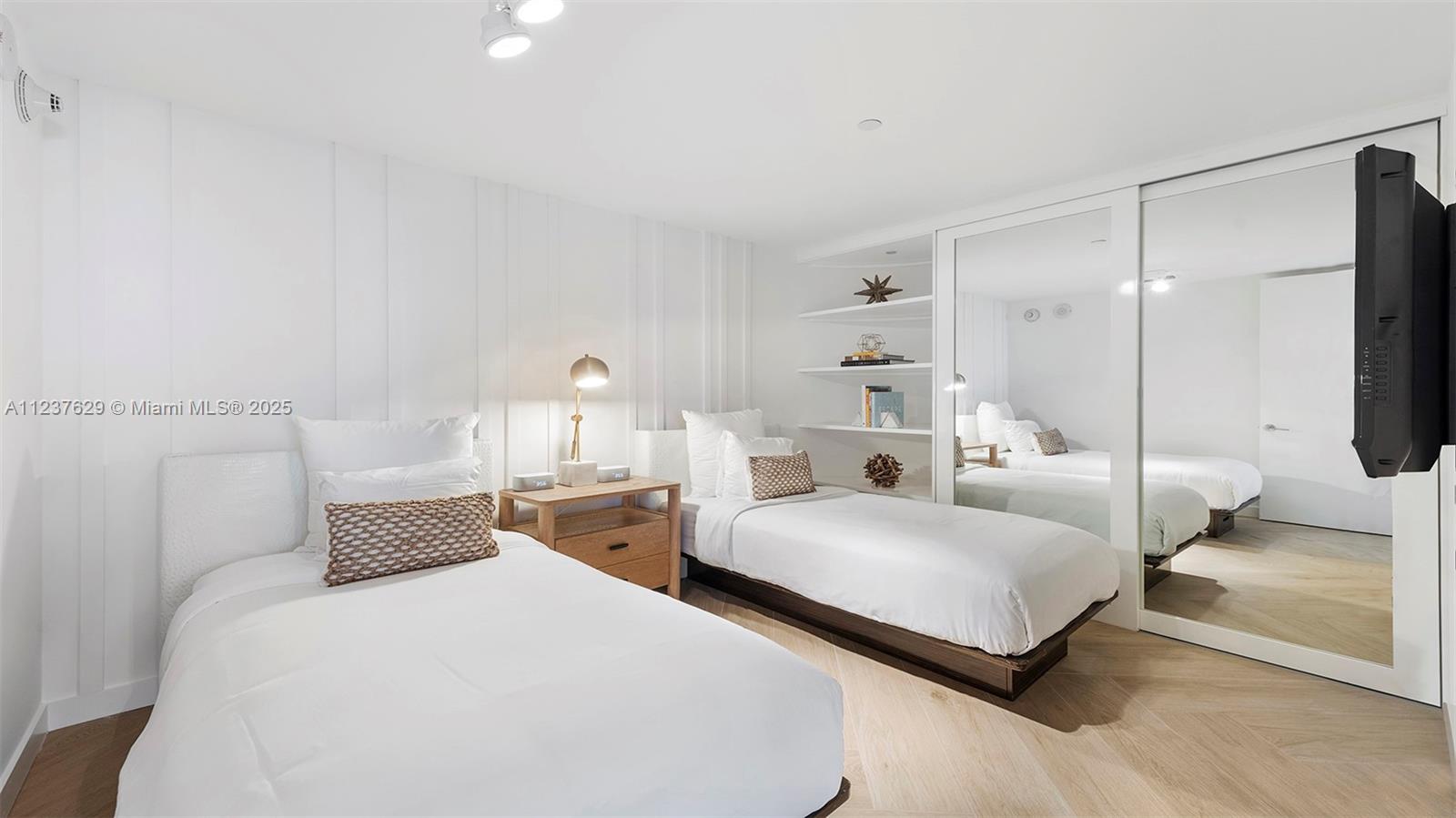 2201 Collins Avenue, Unit 804 Miami Beach, FL 33139 - Photo 31 of 41 a bedroom with two beds and large mirror