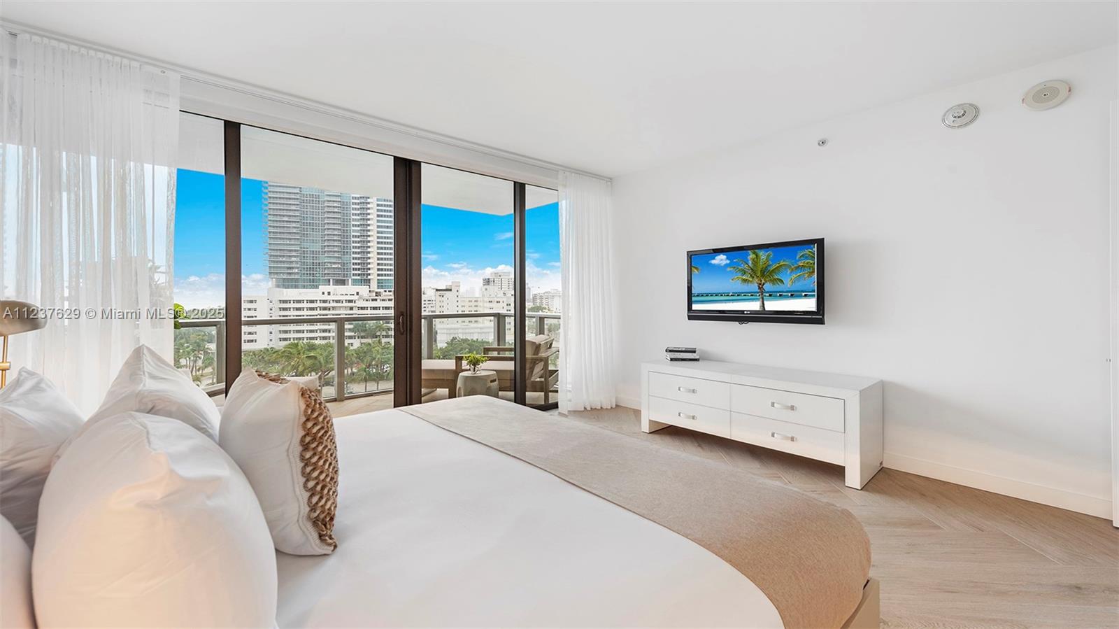 2201 Collins Avenue, Unit 804 Miami Beach, FL 33139 - Photo 40 of 41 a spacious bedroom with a bed and a flat screen tv