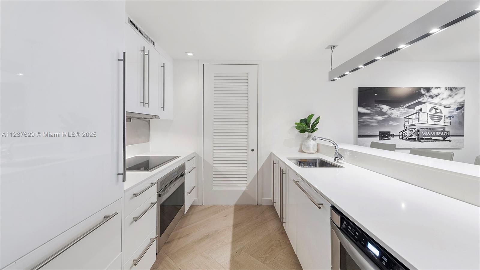 2201 Collins Avenue, Unit 804 Miami Beach, FL 33139 - Photo 4 of 41 a kitchen with a sink and cabinets