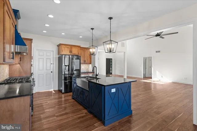 a kitchen with stainless steel appliances granite countertop wooden floors and sink