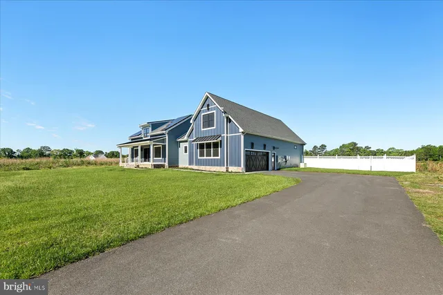 a view of a house with a yard and potted plants
