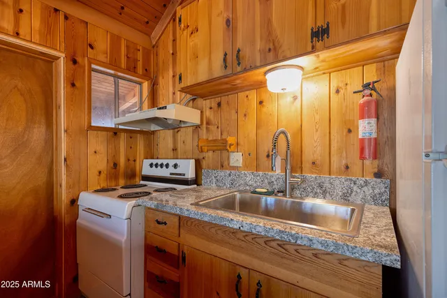 a kitchen with stainless steel appliances granite countertop a sink a stove and a refrigerator