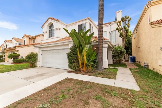 a view of a white house with a small yard and plants