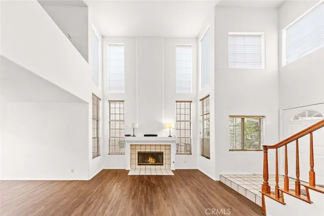 a view of a kitchen with wooden floor electronic appliances and stairs