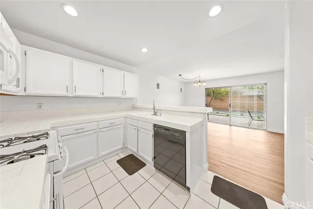 a kitchen with granite countertop white cabinets and white appliances