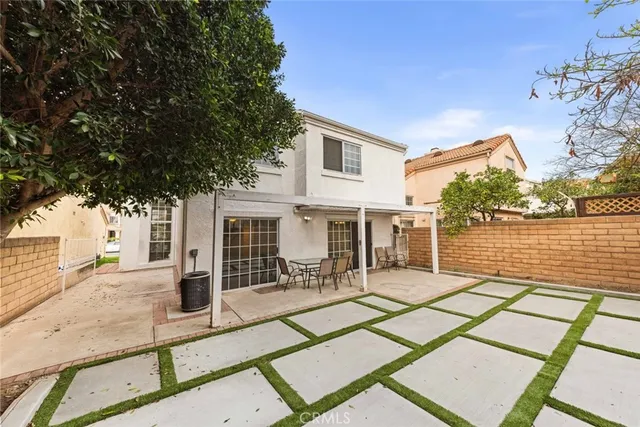 a view of a patio with a table and chairs next to a yard