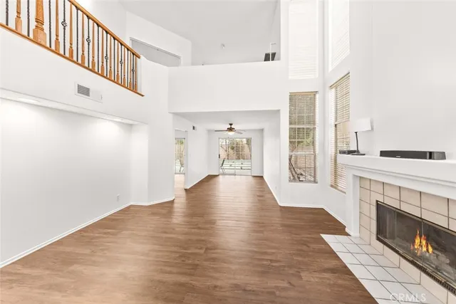 a view of an empty room with wooden floor and a fireplace