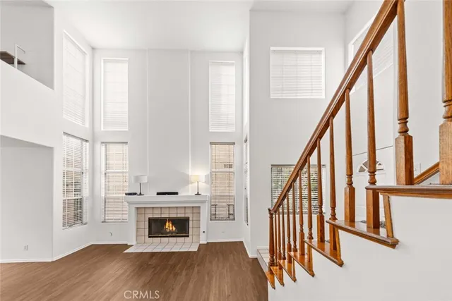 a view of an empty room with wooden floor fireplace and a window