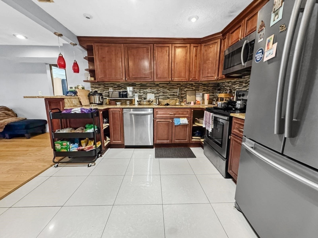 305 Riverside Avenue, Unit 24 Medford, MA 02155 - Photo 6 of 11 a kitchen with stainless steel appliances granite countertop a refrigerator and a stove