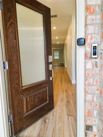 a view of a hallway with wooden floor and staircase