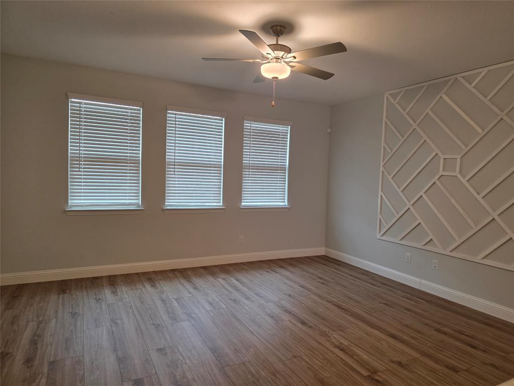 3209 Appleton Street Little Elm, TX 75068 - Photo 3 of 17 Unfurnished room featuring light wood-type flooring, ceiling fan, and a decorative wall