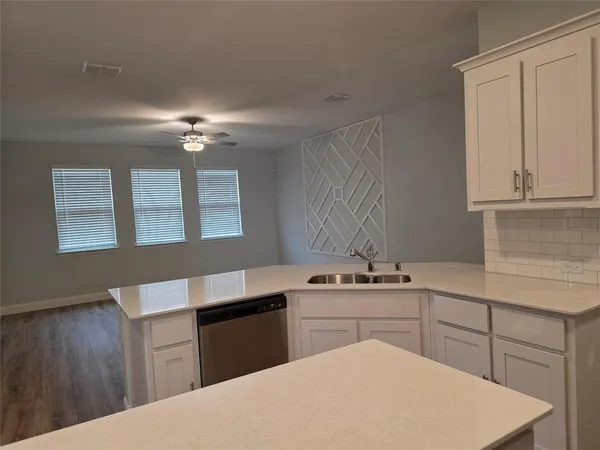 a kitchen with a sink cabinets and wooden floor
