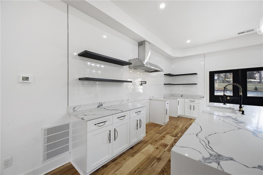 6465 Yacht Club Road Flowery Branch, GA 30542 - Photo 19 of 45 a kitchen with stainless steel appliances a sink a stove and cabinets