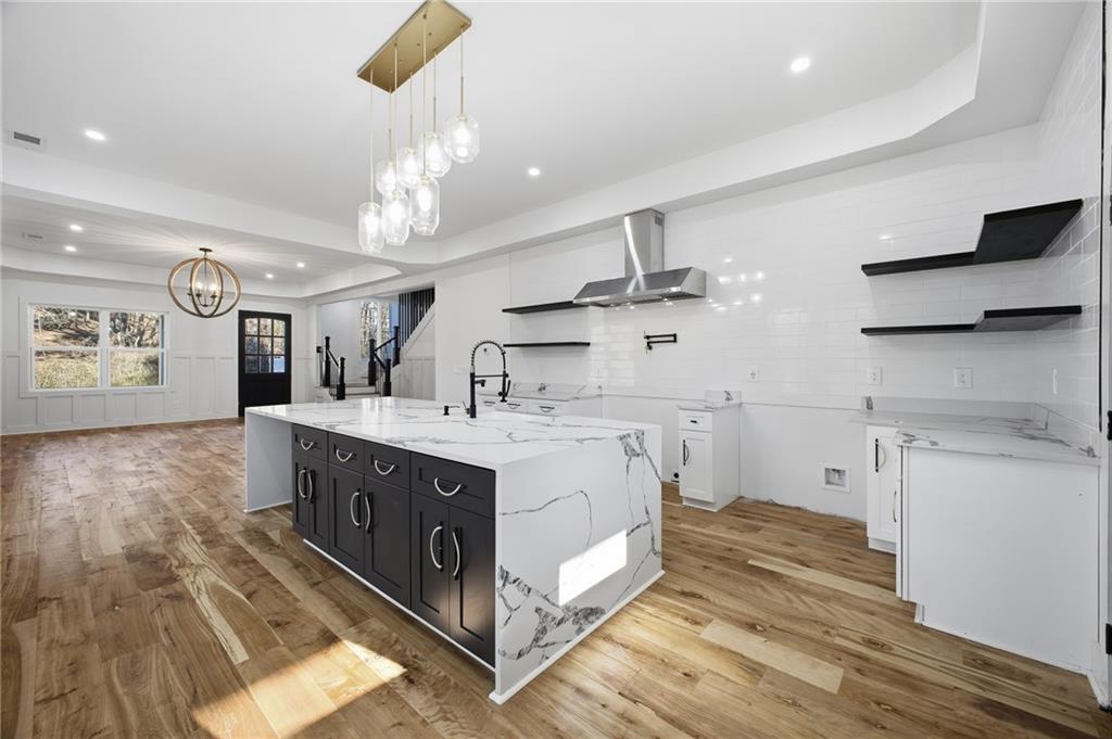 6465 Yacht Club Road Flowery Branch, GA 30542 - Photo 20 of 45 a kitchen with stainless steel appliances granite countertop a lot of counter space and wooden floors