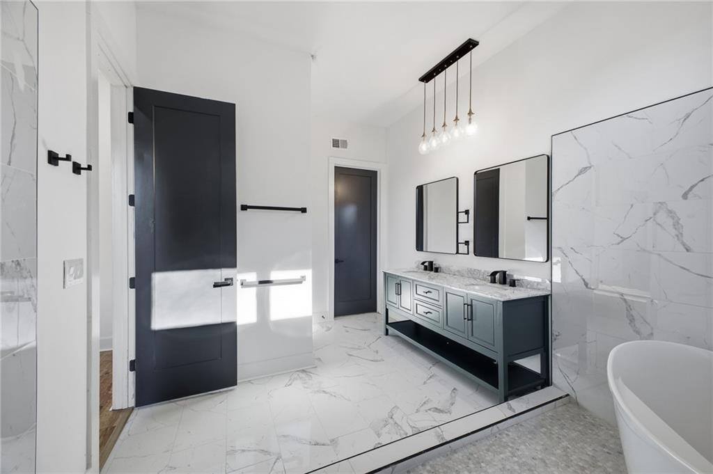 6465 Yacht Club Road Flowery Branch, GA 30542 - Photo 27 of 45 a bathroom with a double vanity sink a toilet a mirror and bathtub