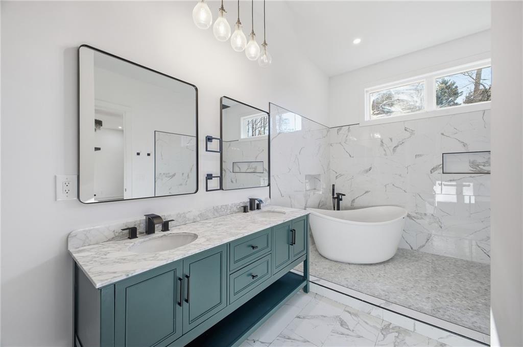 6465 Yacht Club Road Flowery Branch, GA 30542 - Photo 29 of 45 a bathroom with a granite countertop sink mirror and bathtub