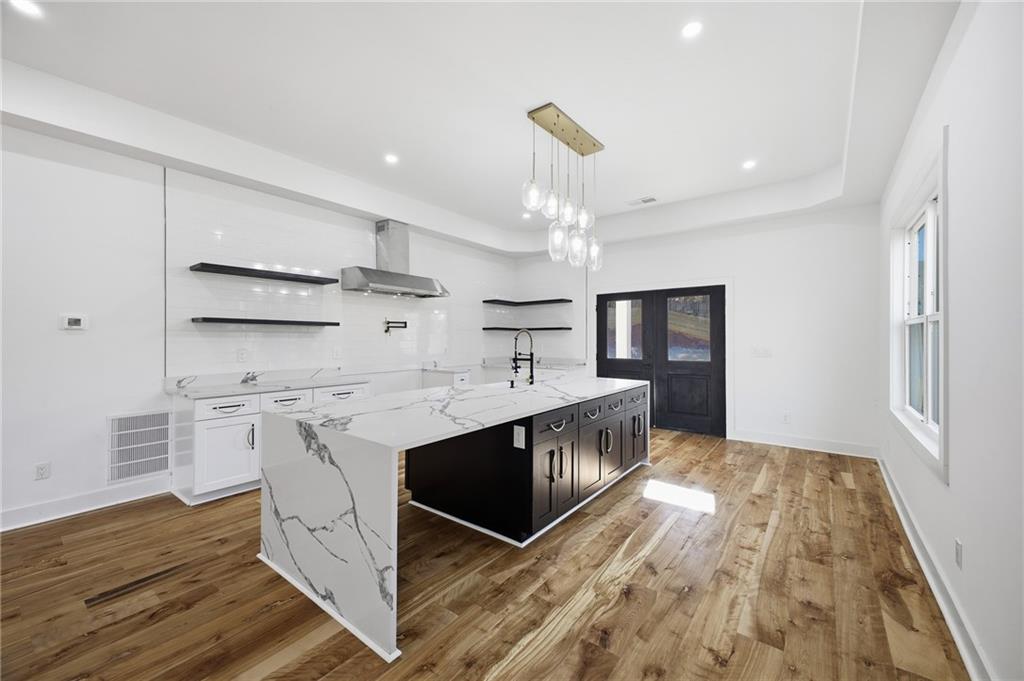 6465 Yacht Club Road Flowery Branch, GA 30542 - Photo 3 of 45 a kitchen with stainless steel appliances granite countertop a sink stove and refrigerator