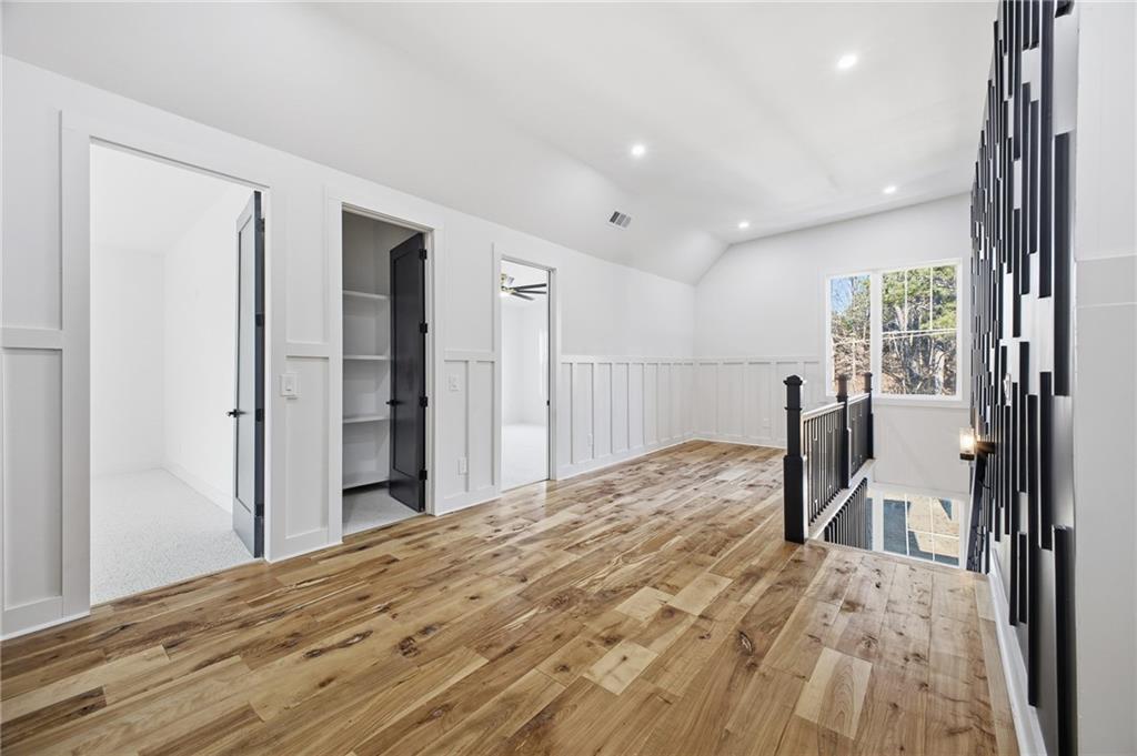 6465 Yacht Club Road Flowery Branch, GA 30542 - Photo 32 of 45 a bedroom with a bed and a large mirror