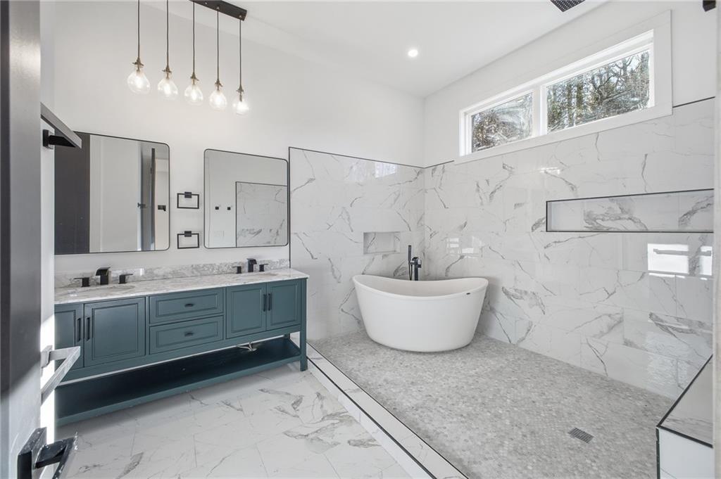 6465 Yacht Club Road Flowery Branch, GA 30542 - Photo 4 of 45 a bathroom with a bathtub sink and mirror