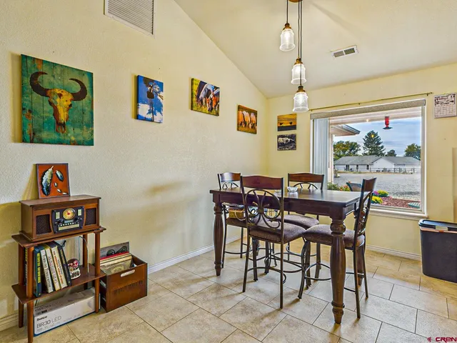 a view of a dining room with furniture a rug and wooden floor