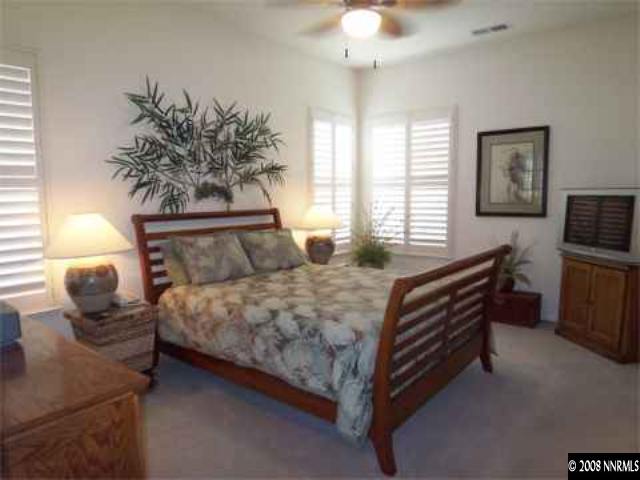 10045 Aniane Street Reno, NV 89521 - Photo 6 of 9 a bedroom with a bed and a chandelier