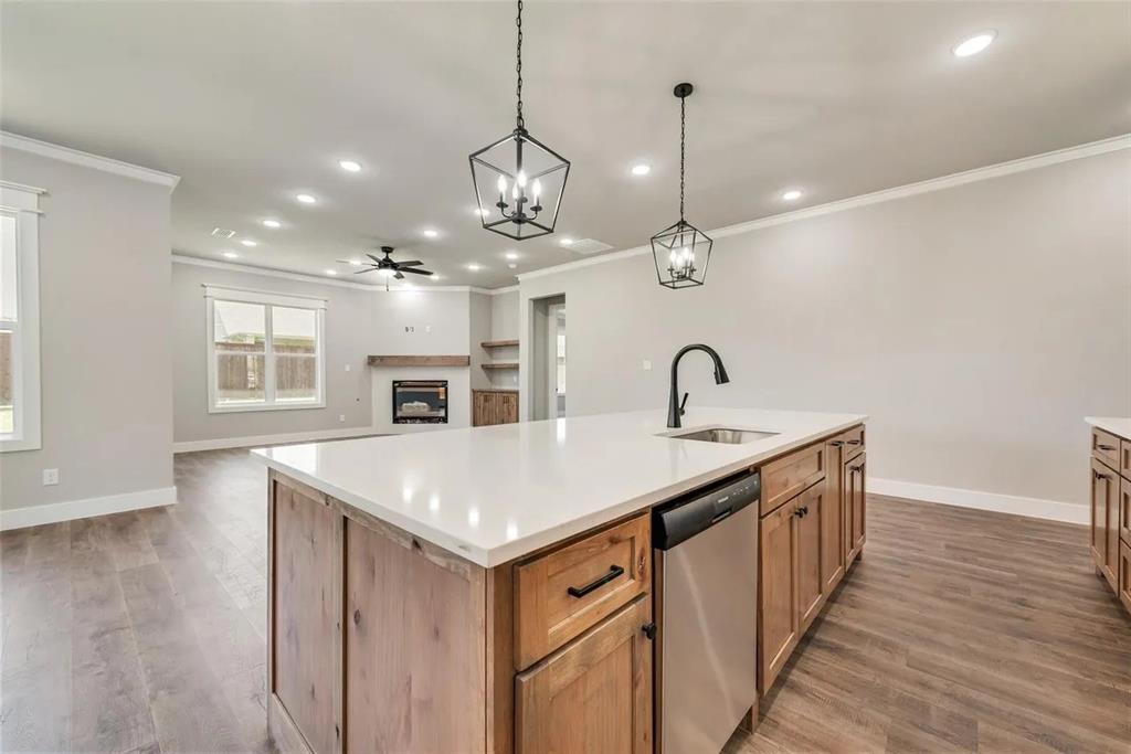 1327 Selby Road Van Alstyne, TX 75495 - Photo 4 of 32 Kitchen with an island with sink, a fireplace, a ceiling fan, light wood finished floors, and dishwasher