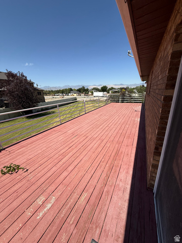 328 Heather Ridge Circle Sandy, UT 84070 - Photo 13 of 32 Expansive outdoor deck with red-stained wood planks and white metal railing