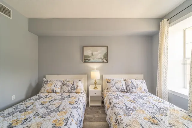 a bedroom with two beds and a large window