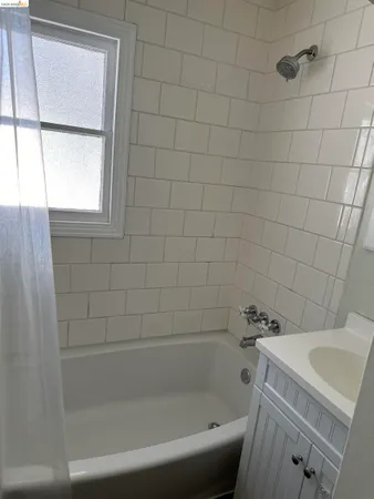 a bath tub sitting next to a white sink and a toilet